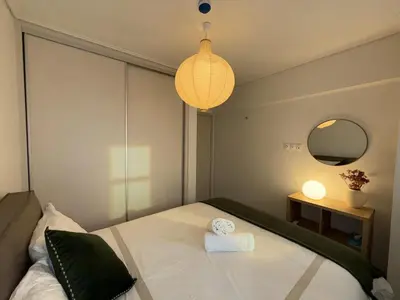 a bedroom with a large white bed with a lamp at Estía Cozy City Apartment in Athens