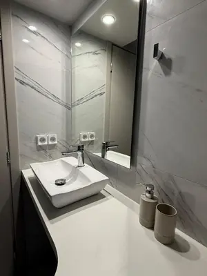a white bathroom with a sink and a mirror at Estía Cozy City Apartment in Athens