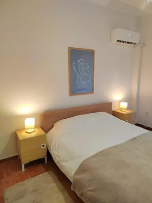 a bedroom with a bed and two night stands with lamps at Tranquil Athenian Home - City Center in Athens