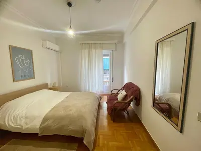 a bedroom with a bed and a chair and a window at Tranquil Athenian Home - City Center in Athens