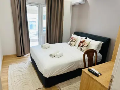 a bedroom with a bed with two towels on it at Brown Balcony Suite No 1, Piraeus Port in Piraeus