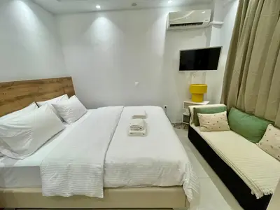 a bedroom with a large white bed and a couch at Athenee Riviera in Athens