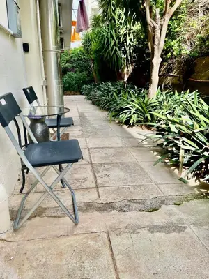 a black chair and a glass table on a patio at Athenee Riviera in Athens