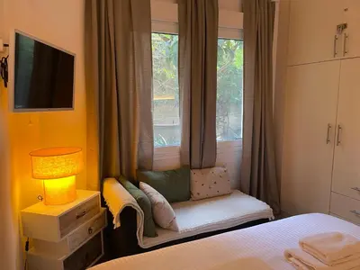 a bedroom with a chair in front of a window at Athenee Riviera in Athens