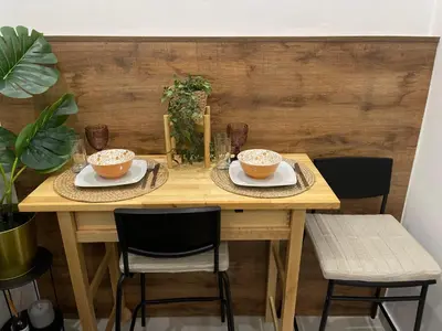a wooden table with two bowls and two chairs at Athenee Riviera in Athens