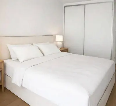 a white bed with white sheets and pillows at Voula Seaview Residence in Athens