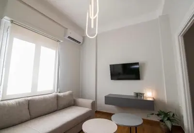 a living room with a couch and a tv at Athens Imperial Suite 1 in Athens