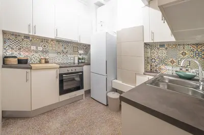 a kitchen with white cabinets and a sink at Athens Imperial Suite 1 in Athens