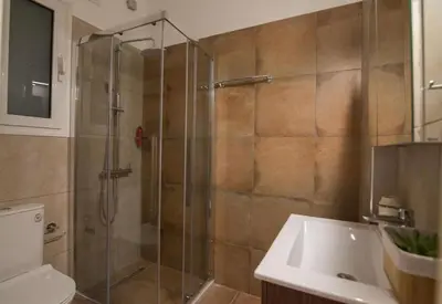 a bathroom with a glass shower with a sink at Athens Imperial Suite 1 in Athens