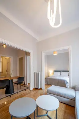 a bedroom with a bed and two tables and a couch at Athens Imperial Suite 1 in Athens