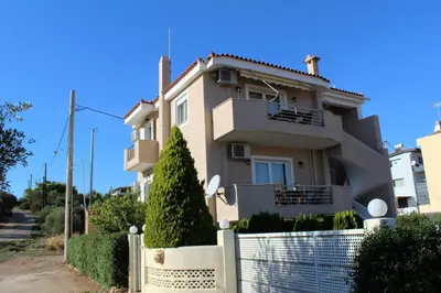 a house with a fence in front of it at Helen's Sounio Apartments in Sounio