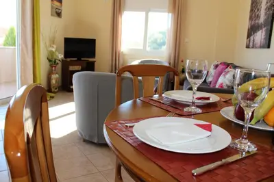 a dining room table with plates and wine glasses at Helen's Sounio Apartments in Sounio