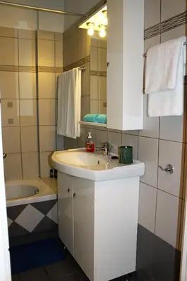 a bathroom with a sink and a bath tub at Helen's Sounio Apartments in Sounio