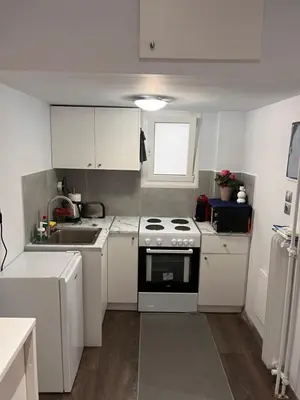 a kitchen with white cabinets and a stove and a sink at Studio by Acropolis in Athens