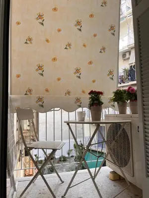 a table and a chair in a room with a curtain at Studio by Acropolis in Athens