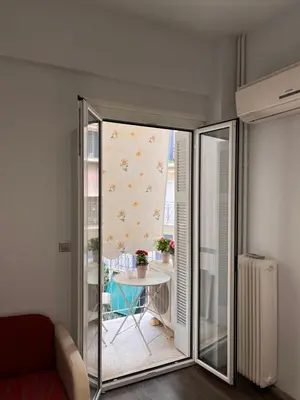 a living room with a sliding glass door and a table at Studio by Acropolis in Athens