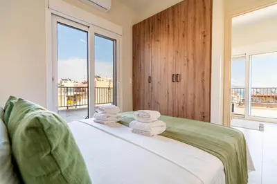 a bedroom with a bed with towels on it at Buena Vista by Pame Rentals in Piraeus