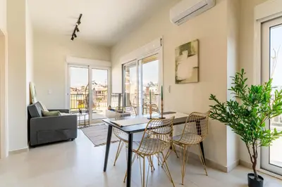 a living room with a table and chairs at Buena Vista by Pame Rentals in Piraeus