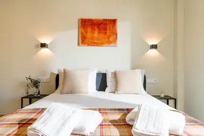 a bedroom with a large bed with white sheets and pillows at Buena Vista by Pame Rentals in Piraeus
