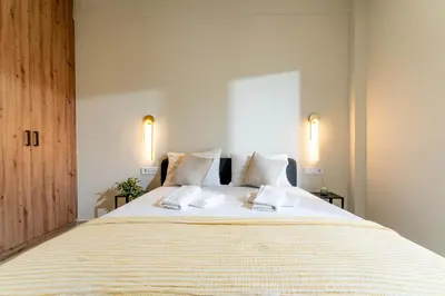 a bedroom with a large white bed with two pillows at Buena Vista by Pame Rentals in Piraeus