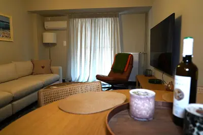 a living room with a bottle of wine on a table at Urban Maisons Kallithea in Athens