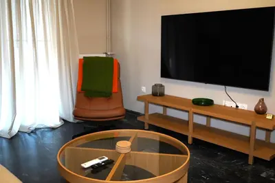 a living room with a flat screen tv and a coffee table at Urban Maisons Kallithea in Athens