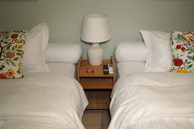 a room with two beds and a table with a lamp at Urban Maisons Kallithea in Athens