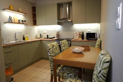 a kitchen with a wooden table and chairs and a counter at Urban Maisons Kallithea in Athens