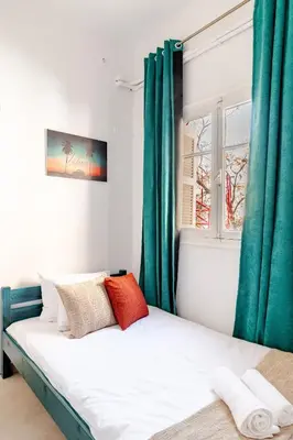 a bed in a room with green curtains at Cozy, Convenient & Athens in Athens