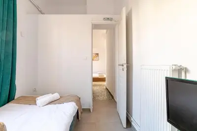 a bedroom with a bed and a flat screen tv at Cozy, Convenient & Athens in Athens