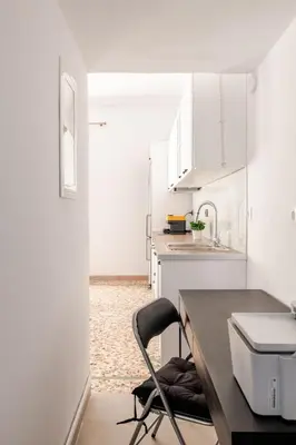 a white kitchen with a desk and a chair at Cozy, Convenient & Athens in Athens