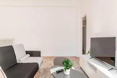 a living room with a couch and a flat screen tv at Cozy, Convenient & Athens in Athens