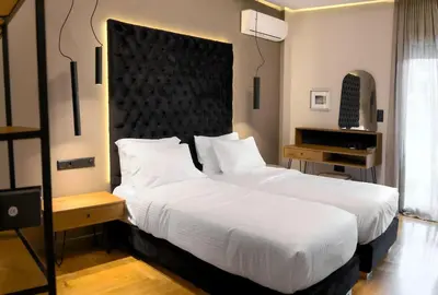 a bedroom with a large white bed with a large headboard at Acropolis Prime Stay in Athens