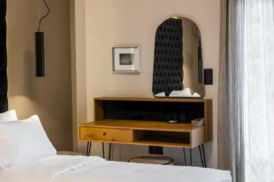 a bedroom with a bed and a dresser with a mirror at Acropolis Prime Stay in Athens
