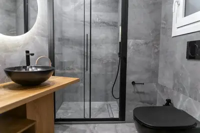 a bathroom with a sink and a glass shower at Acropolis Prime Stay in Athens