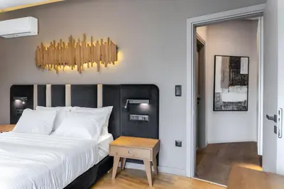 a bedroom with a large bed and a chandelier at Acropolis Prime Stay in Athens
