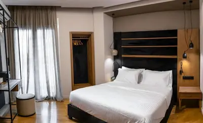 a bedroom with a large white bed with a black headboard at Acropolis Prime Stay in Athens