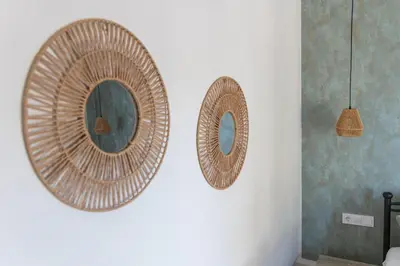 two wicker mirrors on a wall in a room at Villa Keyd Mare in Porto Rafti
