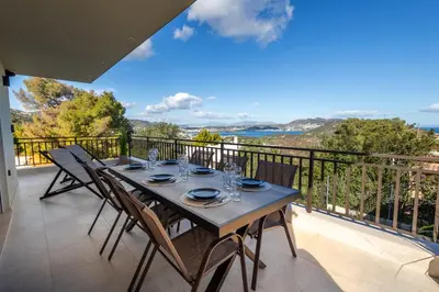 a wooden table with chairs on a balcony at Villa Keyd Mare in Porto Rafti