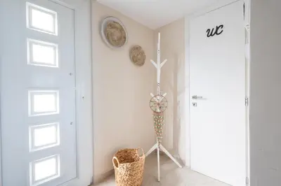 a white room with a door and a basket at Villa Keyd Mare in Porto Rafti