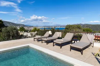 a patio with chairs and a swimming pool at Villa Keyd Mare in Porto Rafti