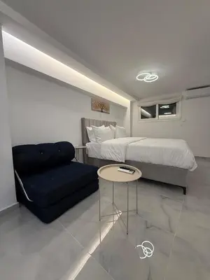 a bedroom with a bed and a couch and a table at City Center Dream Studio in Athens