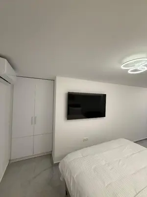 a bedroom with a bed and a tv on the wall at City Center Dream Studio in Athens