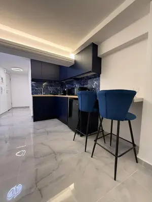a kitchen with blue cabinets and blue chairs at City Center Dream Studio in Athens