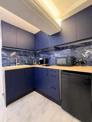 a kitchen with blue cabinets and a counter top at City Center Dream Studio in Athens