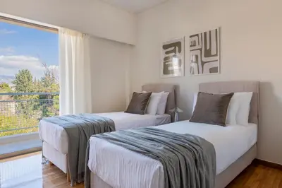 two beds in a room with a window at Comfort Living 3BR Apartment in Chalandri by UPSTREET in Athens