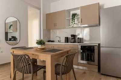 a kitchen with a wooden table and a refrigerator at Athens Urban Vibes 2 Backyard Bliss Patio in Athens
