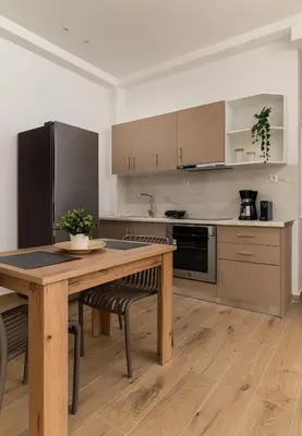 a kitchen with a wooden table with chairs and a tableasteryasteryasteryasteryastery at Athens Urban Vibes 5 Cozy Balcony Renovated in Athens