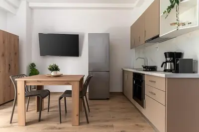 a kitchen with a wooden table and a kitchen with a refrigerator at Athens Urban Vibes 5 Cozy Balcony Renovated in Athens