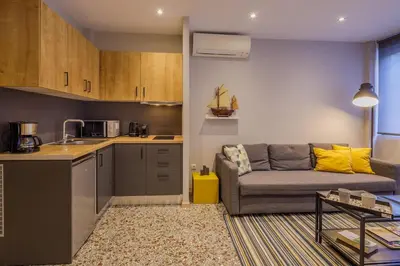 a living room with a couch and a kitchen at Cozy loft at Little Kook's alley, Psirry heart in Athens